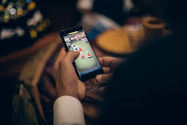 A man celebrating a winning moment on his laptop while gaming symbols float around him, capturing the excitement of BDOK games.