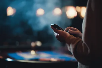 A glowing roulette wheel with cascading chips, symbolizing the engaging live and instant-win games available on BDOK.